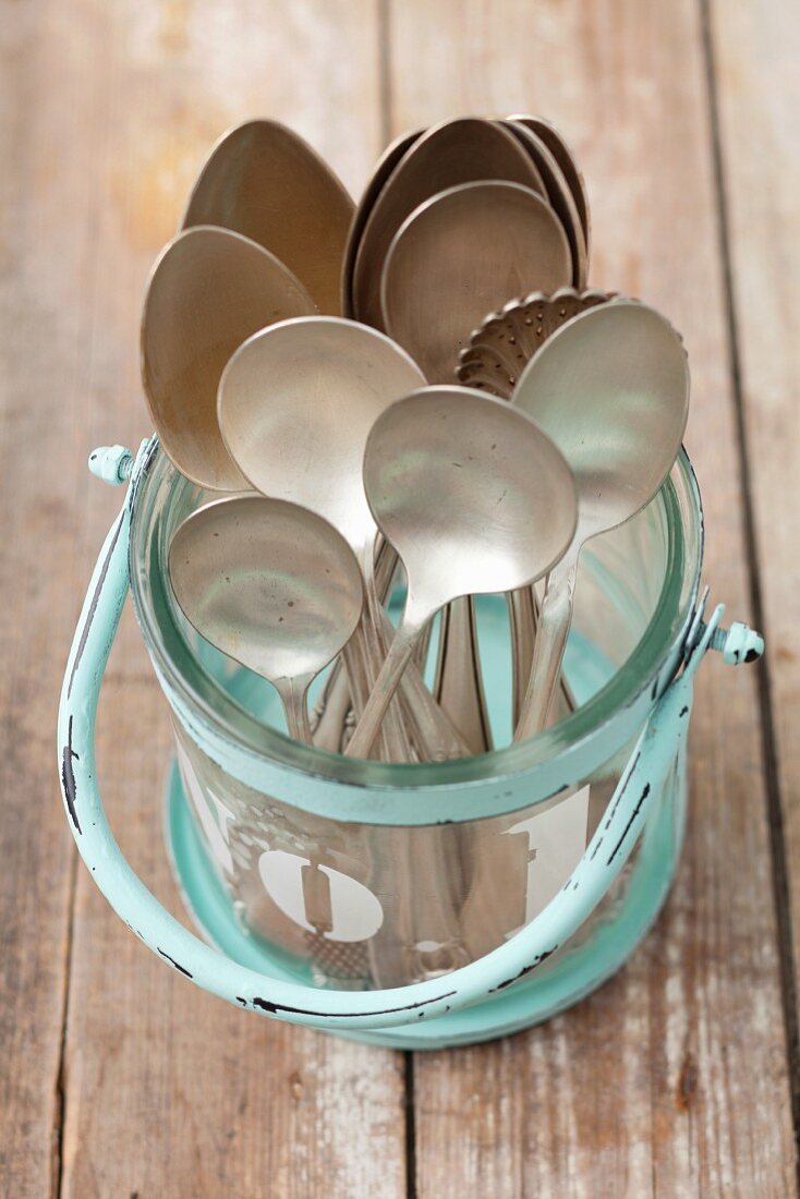 Old spoons in a glass container