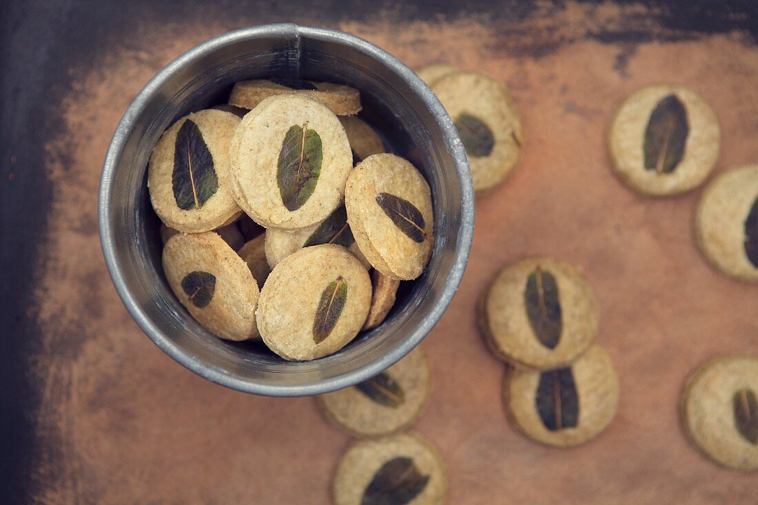 Grüner-Tee-Cookies mit Minze im Metalleimer auf Vintage-Holztisch