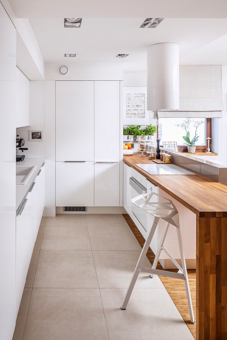 Designer kitchen with smooth, white doors and engineered wood counter