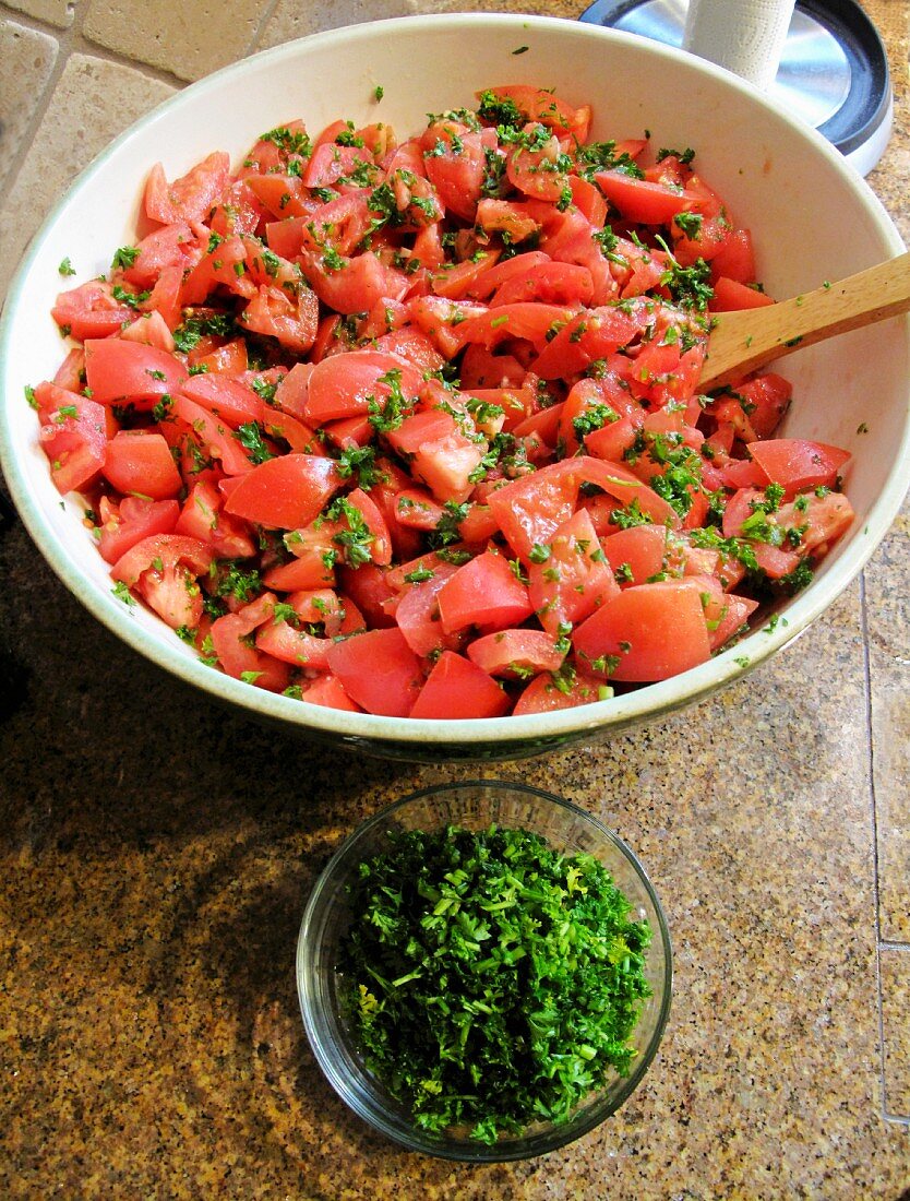 A bowl of sliced tomatoes with parsley