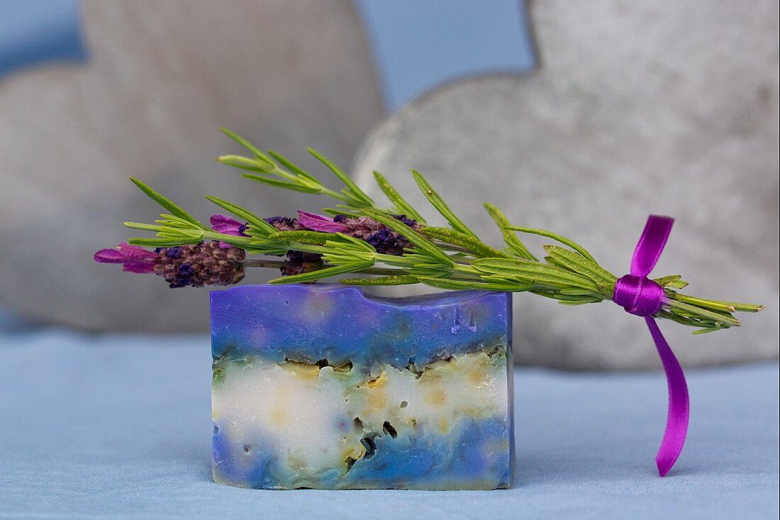 Sprig of fresh lavender on bar of handmade lavender soap