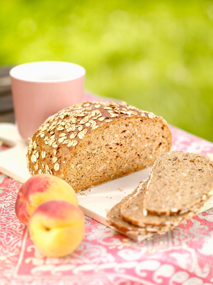 Wholemeal bread with oats and peaches on a garden table