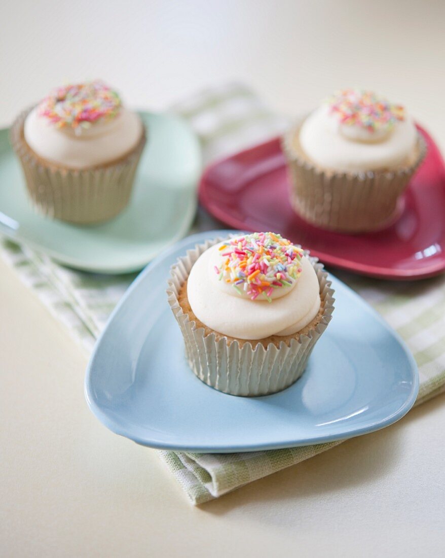 Vanilla cupcakes decorated with coloured sugar sprinkles