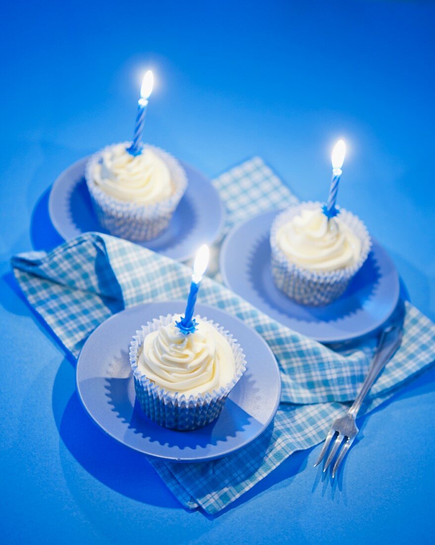 White chocolate cupcakes with blue candles