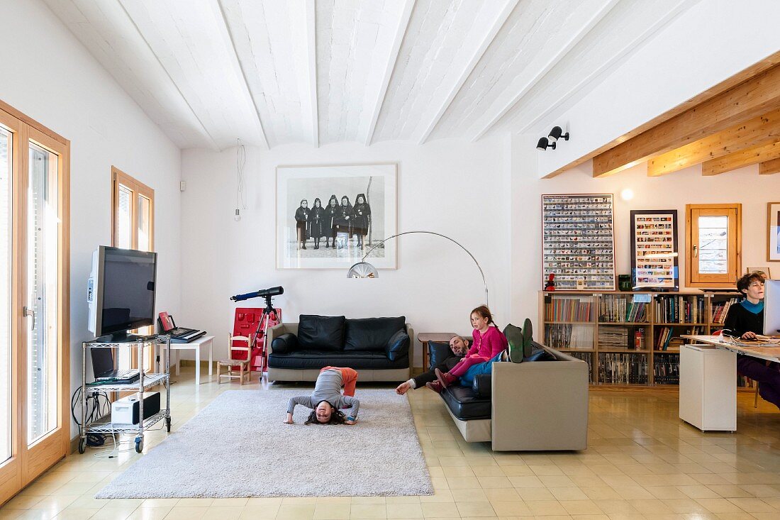 Family life in open-plan living area with comfortable, designer-style leather sofas