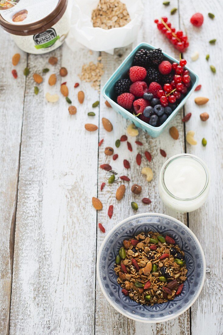 A muesli mixture, yoghurt, fresh berries and a jar of coconut fat