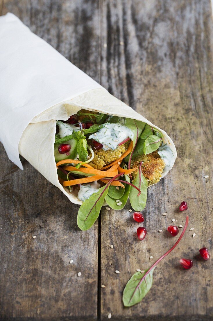 Wrap mit Falafel, Granatapfelkernen, Minze, Gurke, Rote-Bete-Blättern und Dilljoghurt