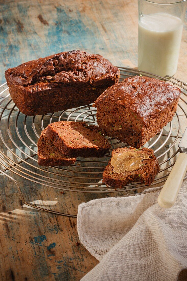 Banana bread, whole and sliced on a cooling rack