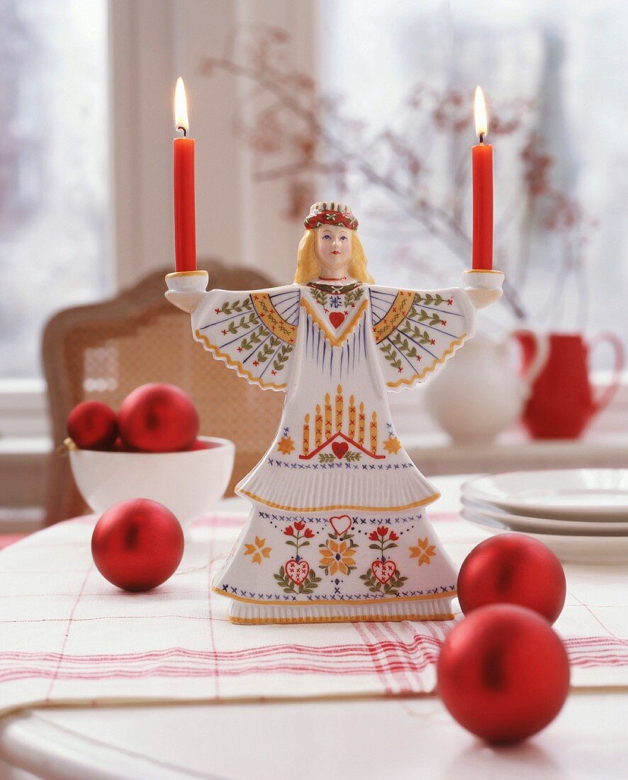 Scandinavian, Saint-Lucy candlestick and red Christmas-tree baubles on table