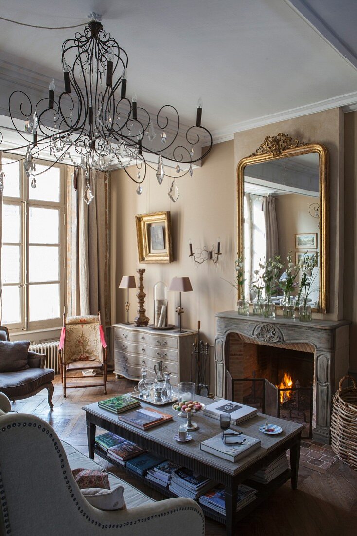 Antique furniture and seating area in front of open fireplace with marble surround