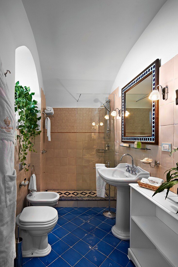 Traditional bathroom with blue tiled floor and shower area with glass screen (Villa Cimbrone Hotel)