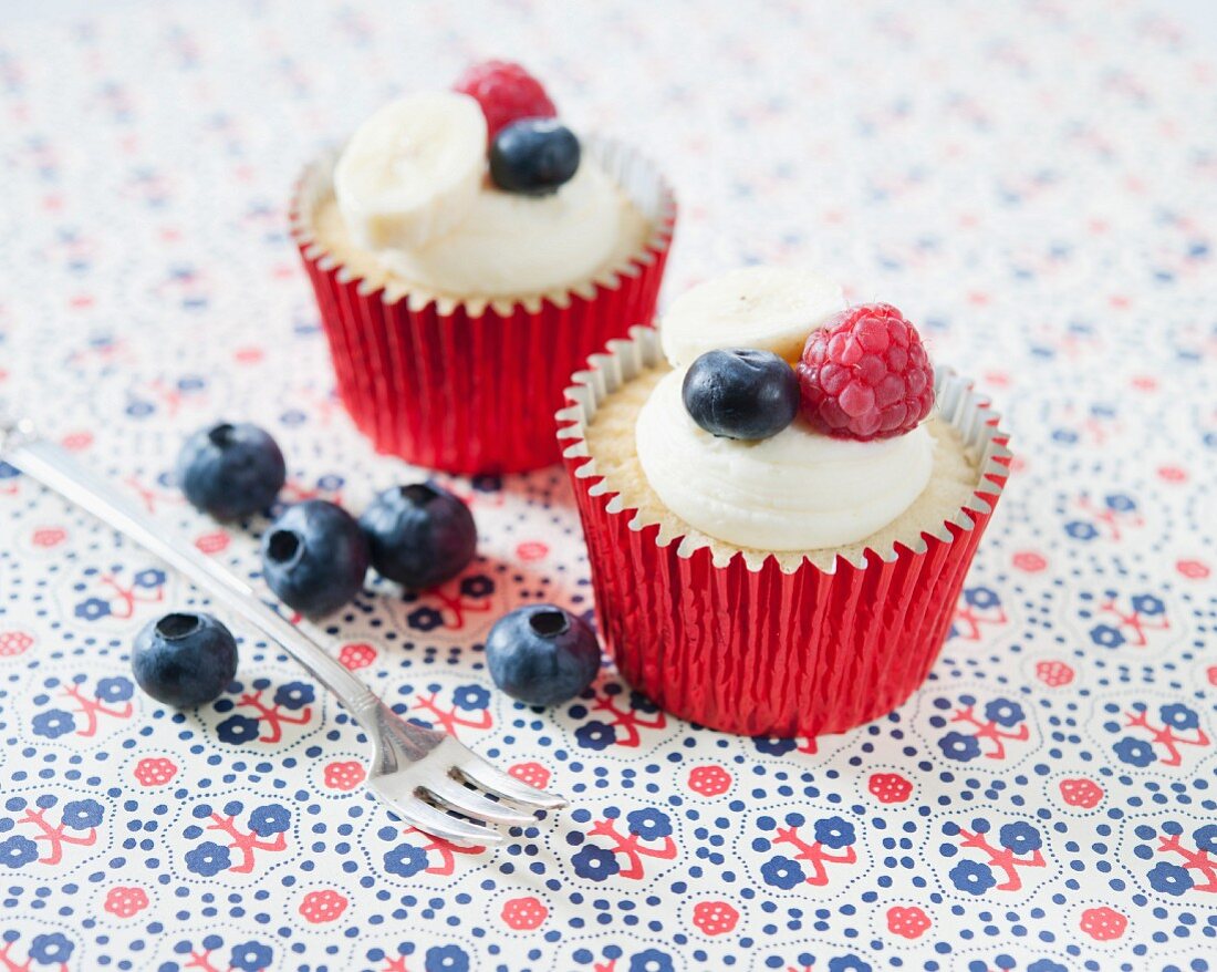 Banana cupcakes decorated with raspberries and blueberries