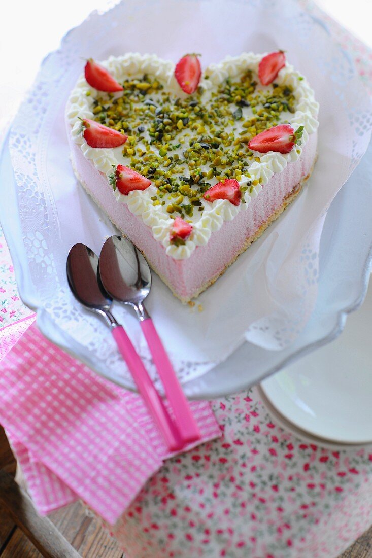 A strawberry heart cake with pistachios