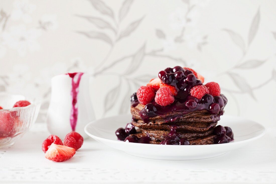 A stack of chocolate pancakes with berries