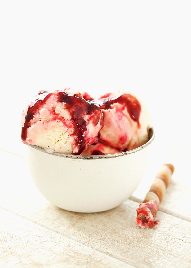 Vanilla and raspberry ice cream with raspberry sauce and wafer rolls