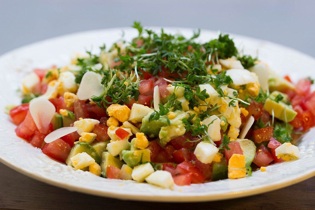 Avocado salad with eggs, tomatoes, cress and onions