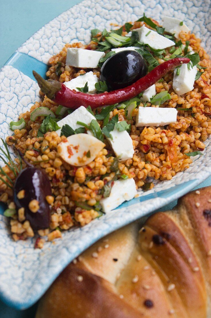 Bulgur salad with feta cheese, olives, chilli peppers and herbs