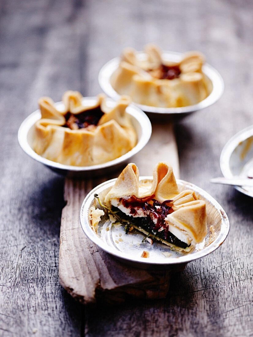 Three shortcrust onion tartlets with spinach and sheep's cheese