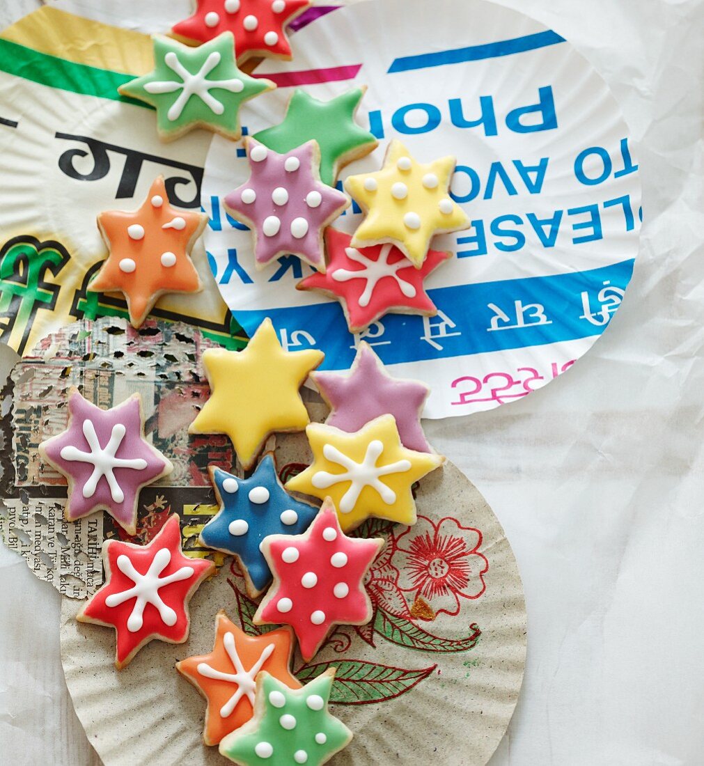 Colourful Christmas star biscuits on paper plates
