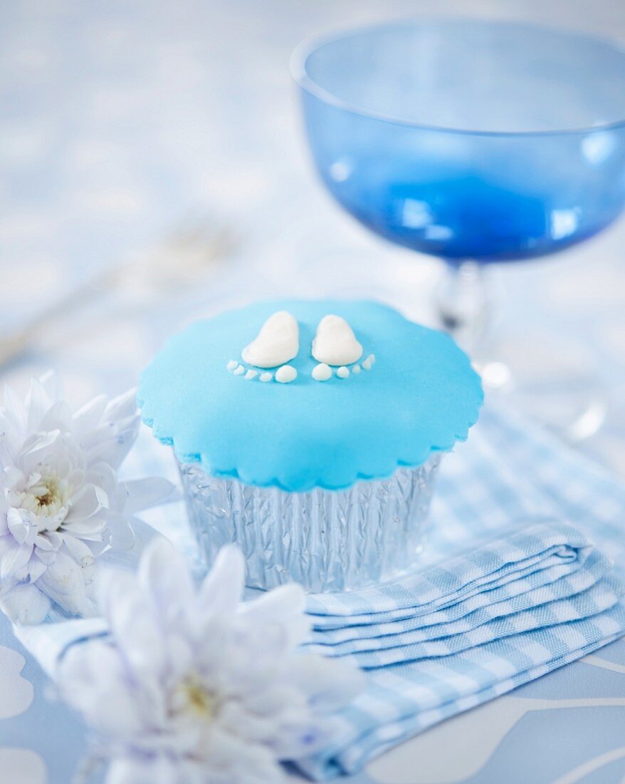 A cupcake decorated with baby feet