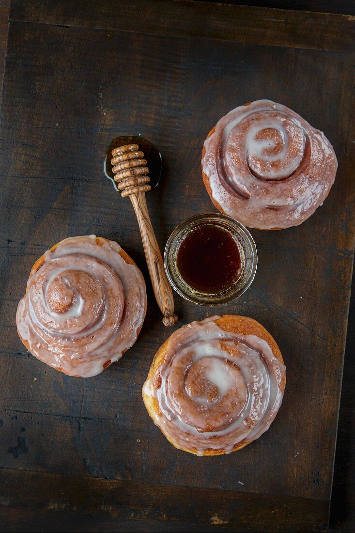 Three glazed cinnamon buns with honey