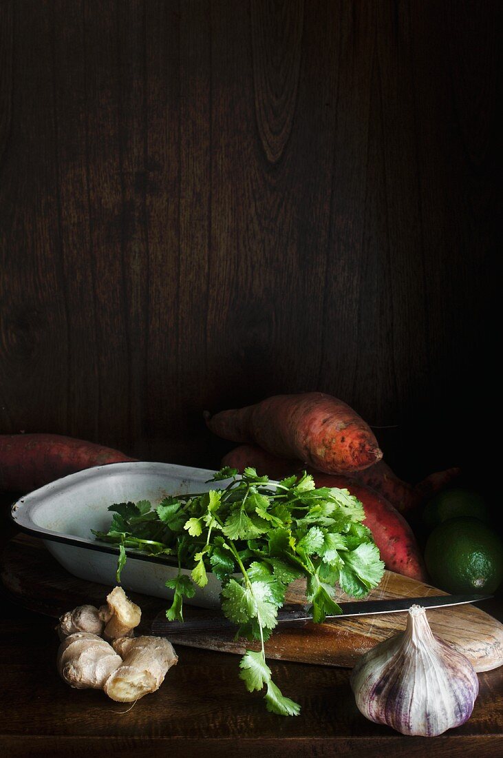 An arrangement of ingredients with sweet potatoes, ginger, coriander and garlic
