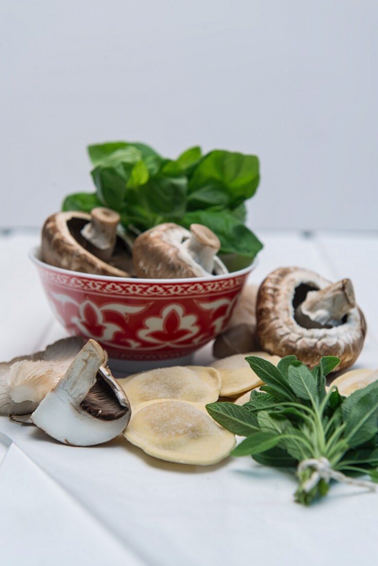 An arrangement of ingredients with ravioli, mushrooms and herbs