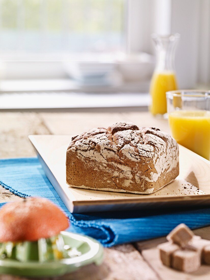 Eckiges Roggenbrot auf flachem Holztablett