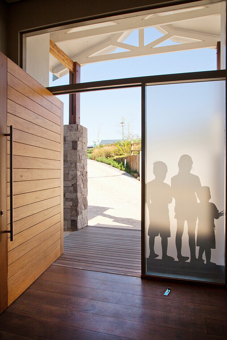 Entrance area with wooden door, frosted glass panes and children's shadows