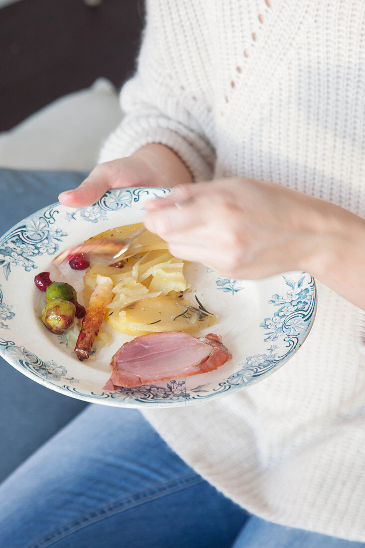 Weihnachtsessen auf Teller mit Schinkenbraten und Beilagen