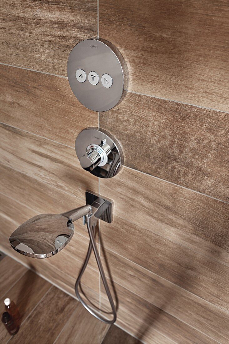 A designer tap with an intuitive pictogram operating panel in a walk-in shower