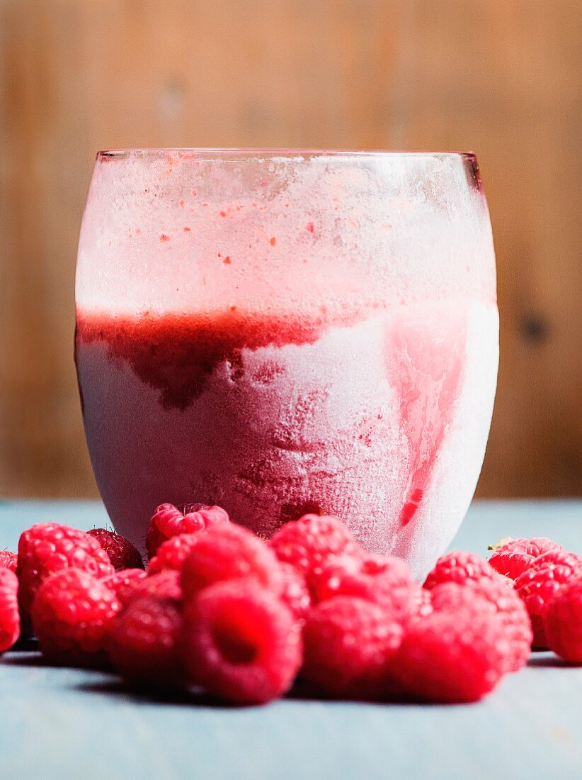 A frozen raspberry smoothie with fresh raspberries
