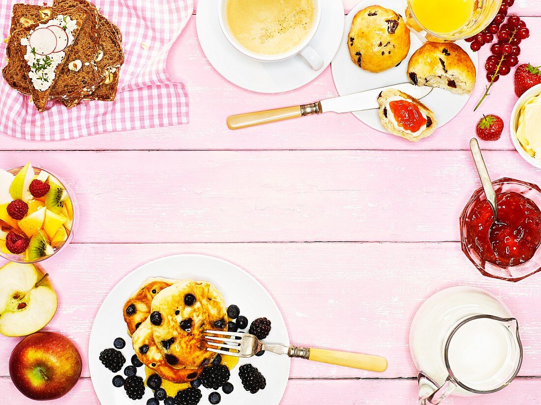 Frühstückstisch mit Scones, Pancakes, Brot & Obstsalat (Aufsicht)