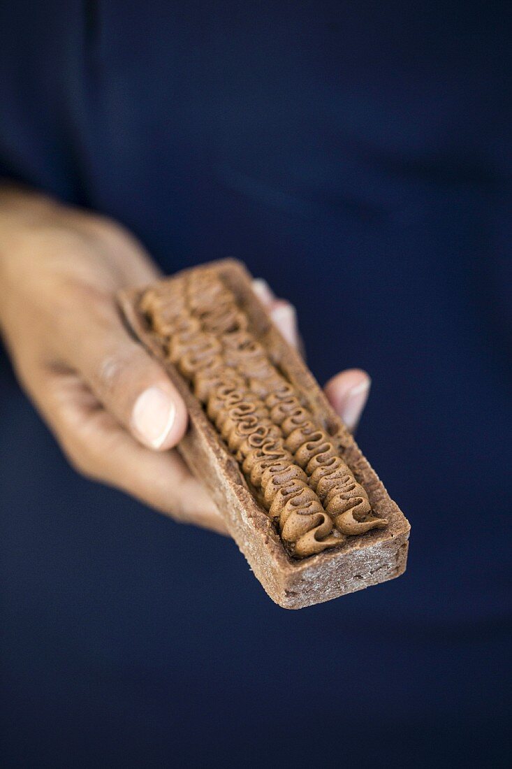 A woman holding a chocolate mousse tart