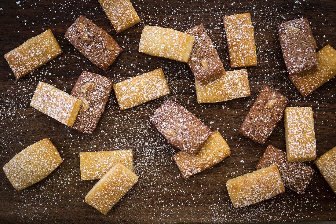 Financiers dusted with icing sugar on a wooden surface