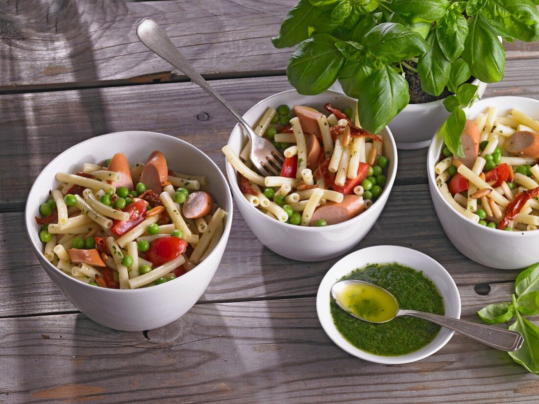 Pasta salad with peas, tomatoes and sausages