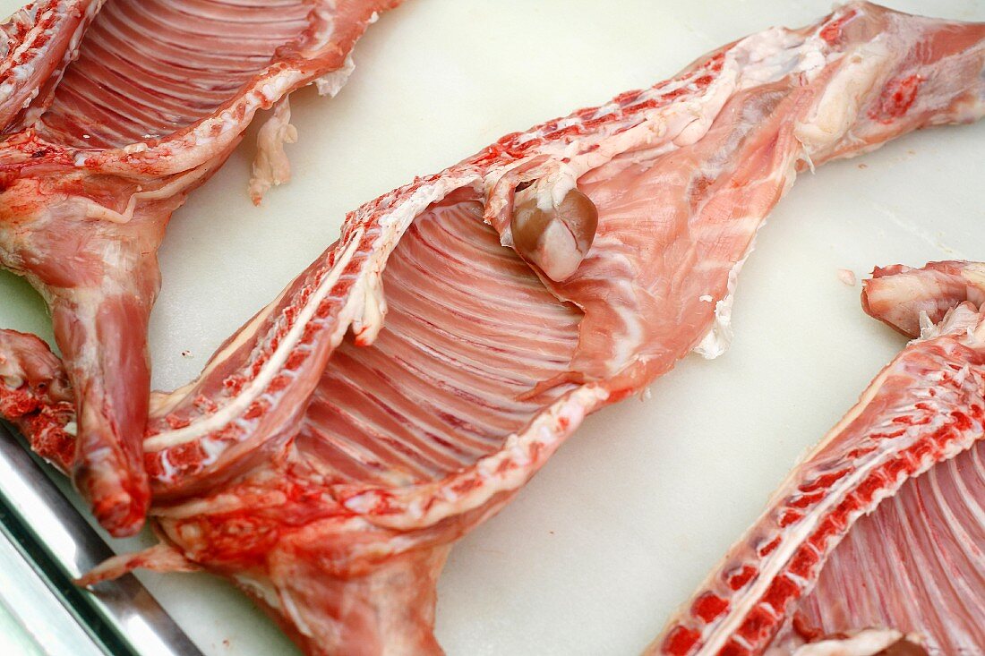 Sides of lamb of on display at La Boqueria market in Barcelona, Spain