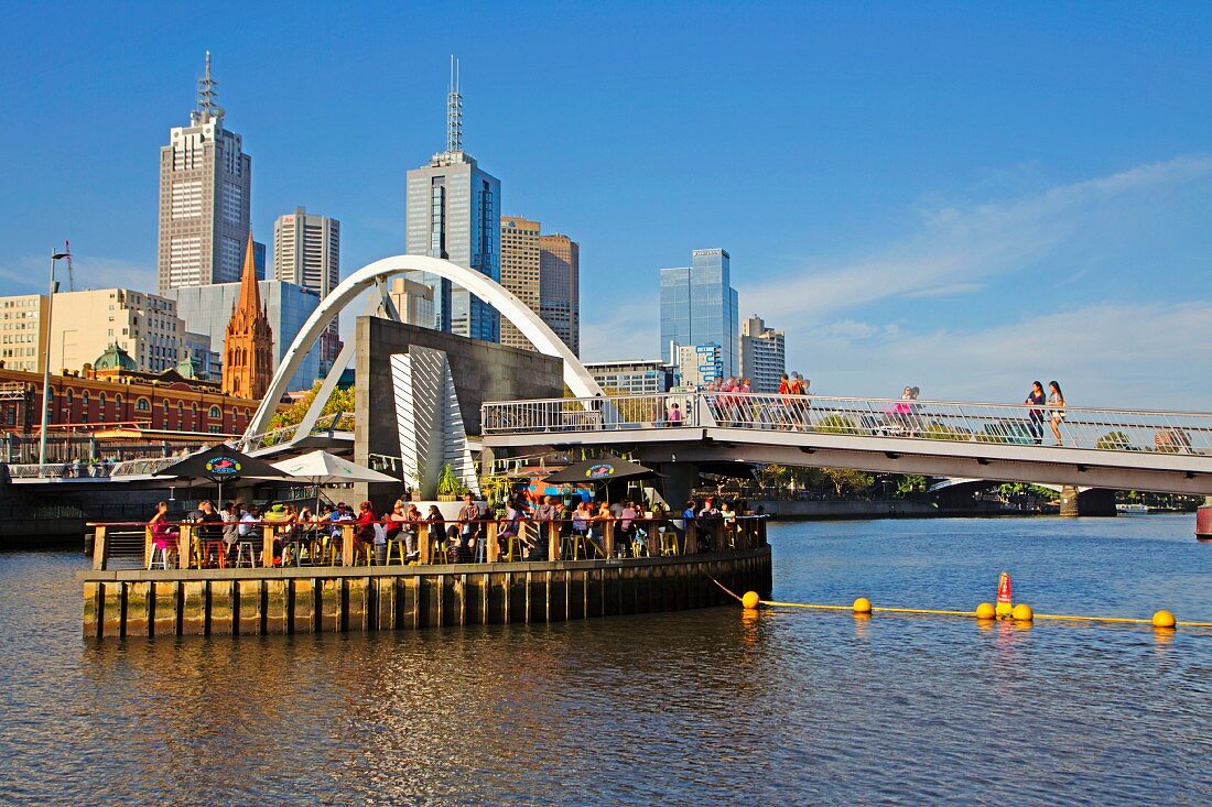Open-air bar Ponyfish Island under the pedestrian bridge over the Yarra River, Skyline Downtown, Melbourne, Australia