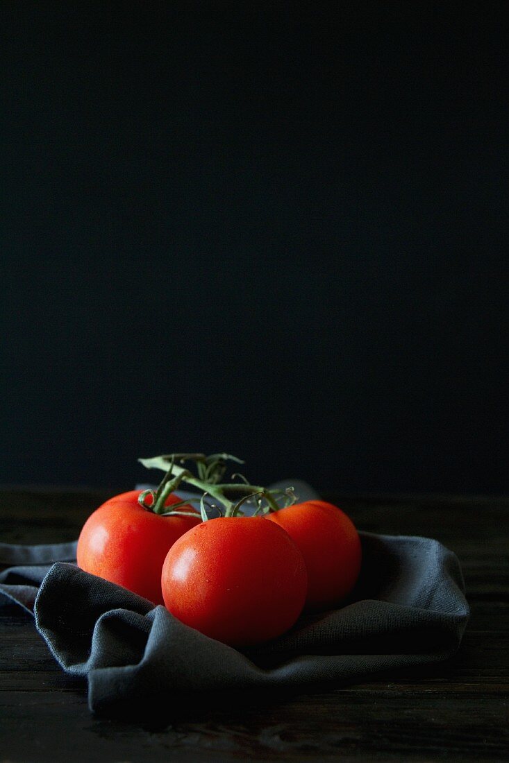 An arrangement of tomatoes with a black napkin