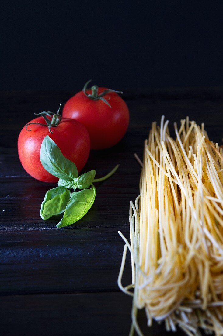 An arrangement of tomatoes, basil and spaghetti
