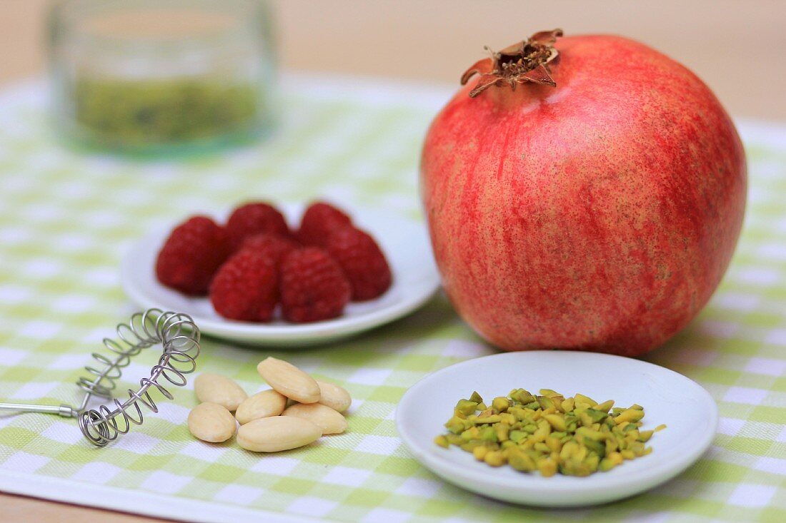 A pomegranate, nuts and raspberries
