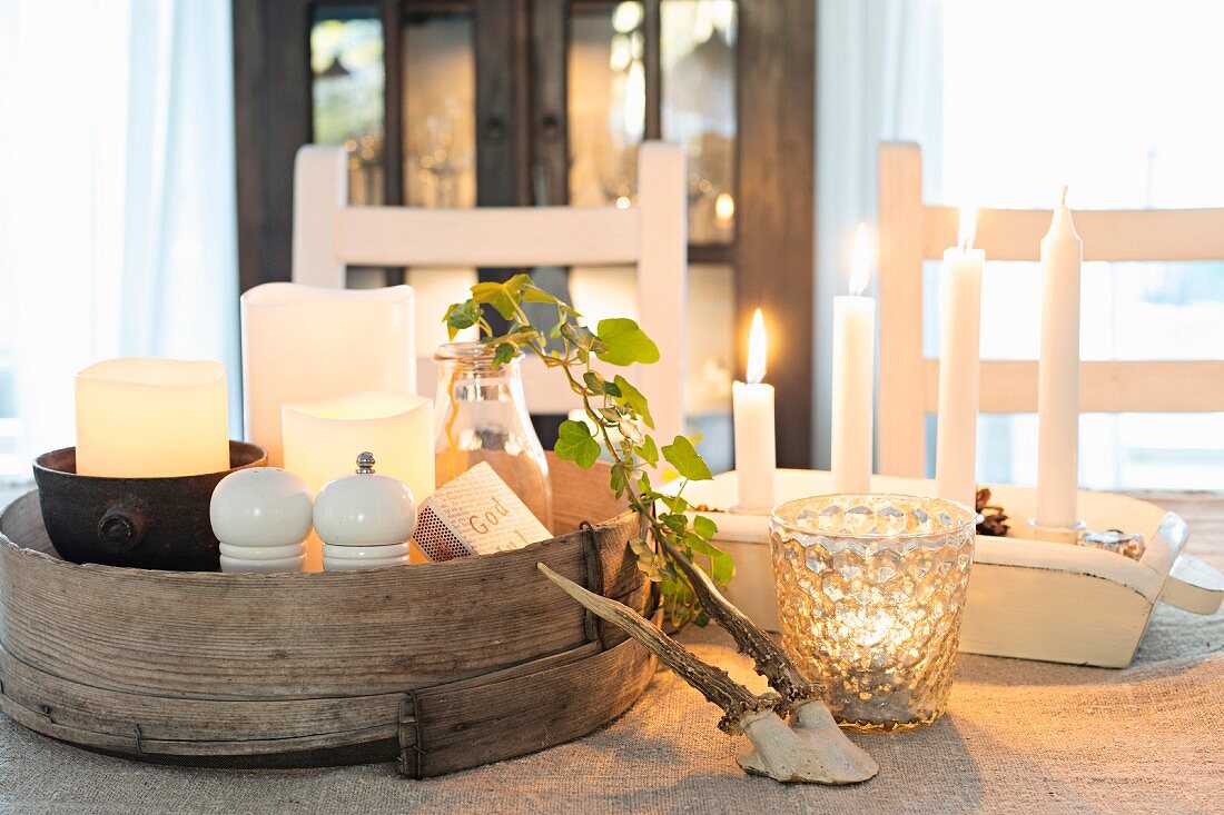 Wintry arrangement of lit candles on table