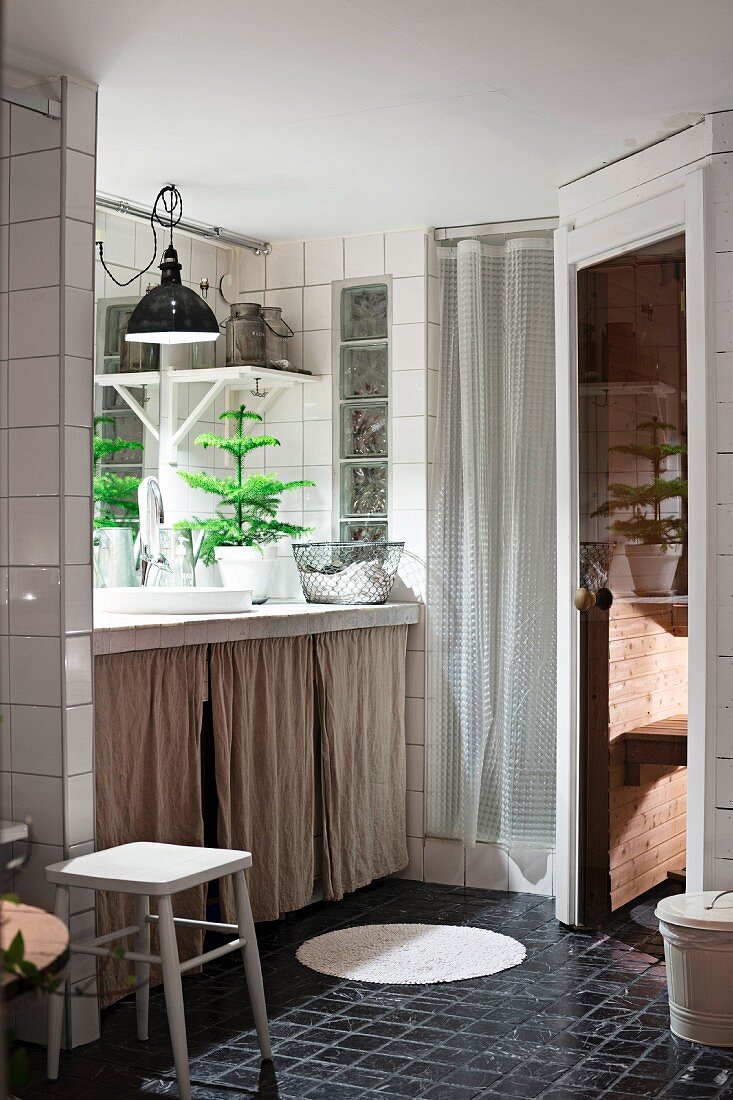 Badezimmer mit Sauna und Vorhängen vor dem Waschtisch