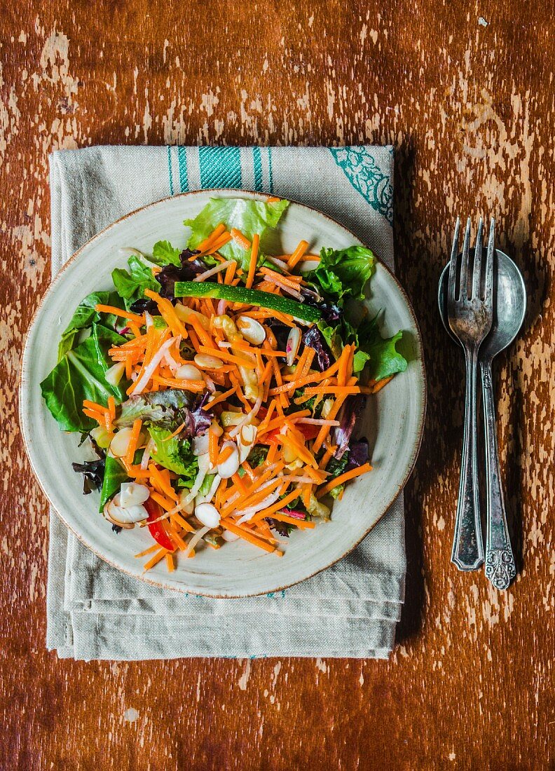 Spinach salad with grated carrots, courgette and raisins