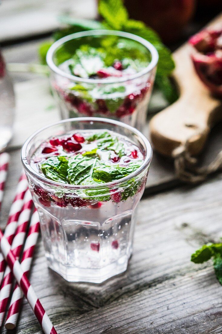 Detox drinks with lemon water, mint and pomegranate seeds