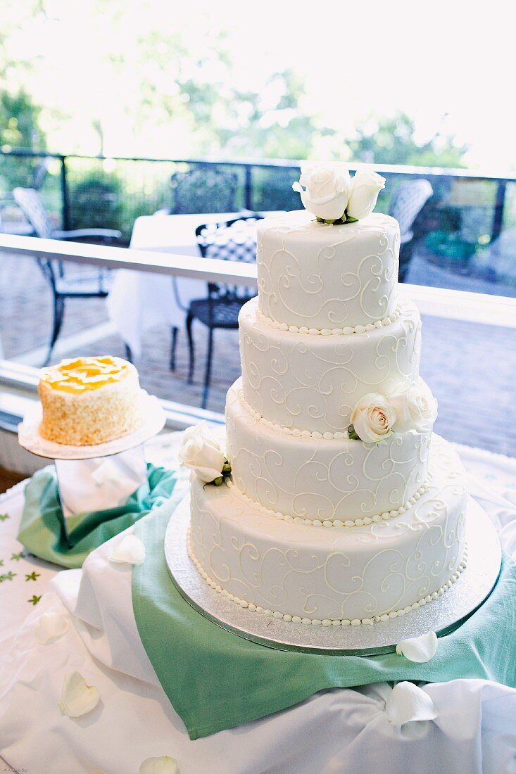 A four-tiered wedding cake on a cake buffet