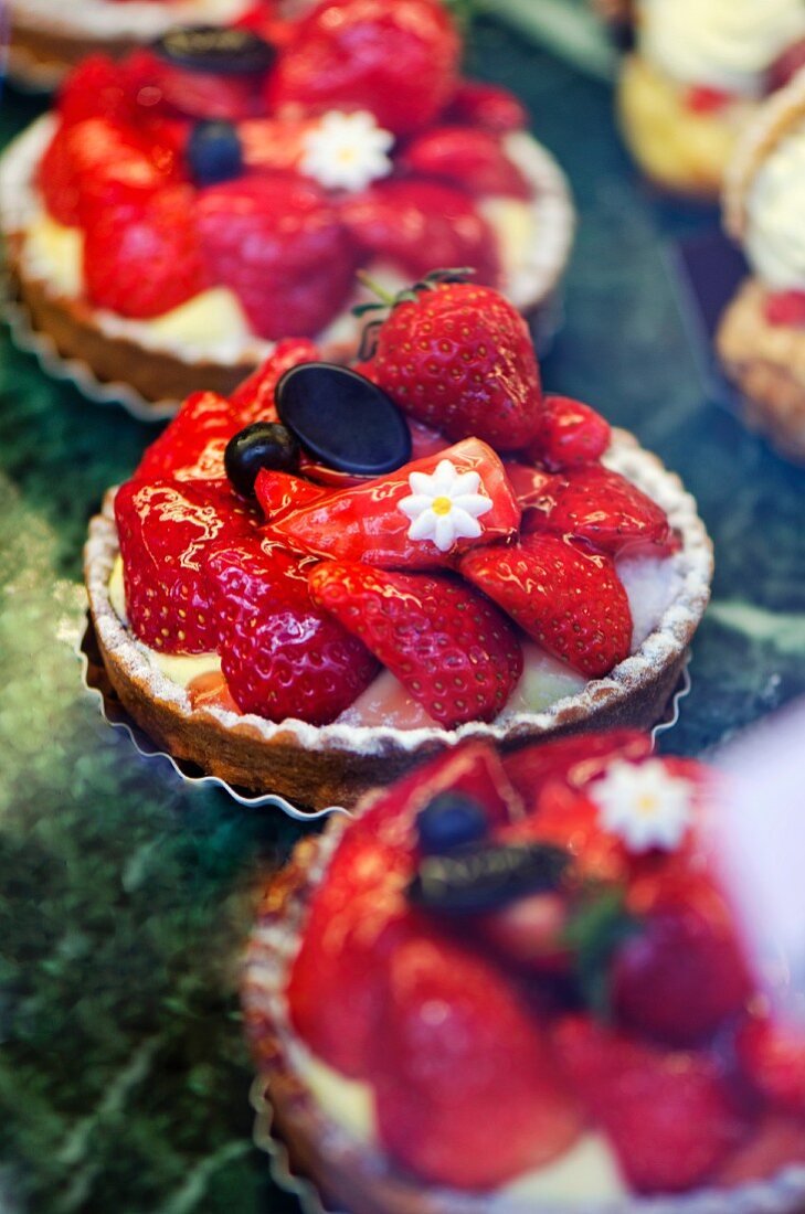 Strawberry tartlets on display in a bakery