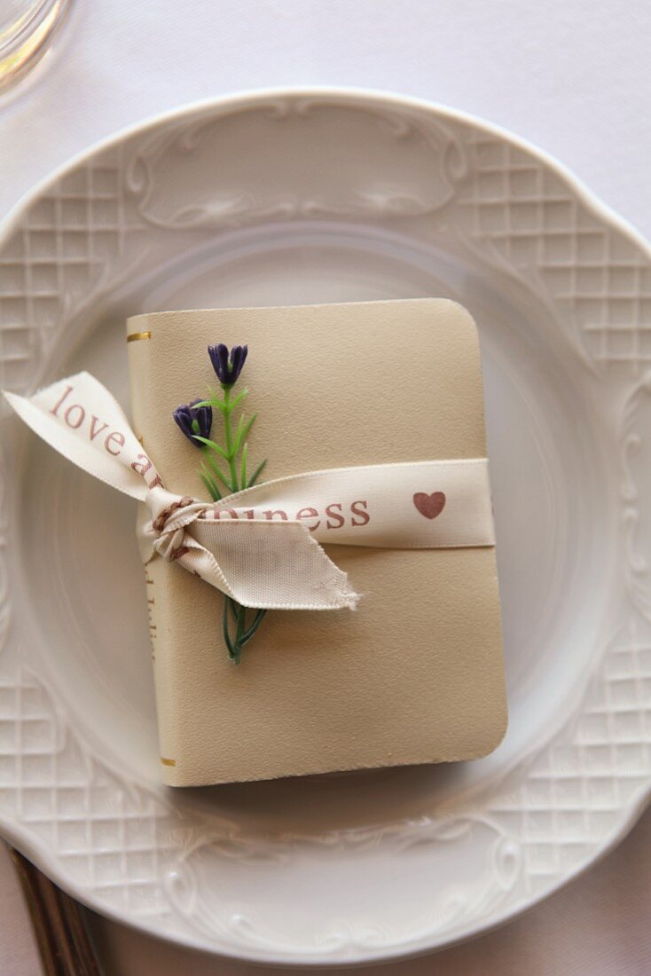 Small book tied with ribbon as table decoration for wedding