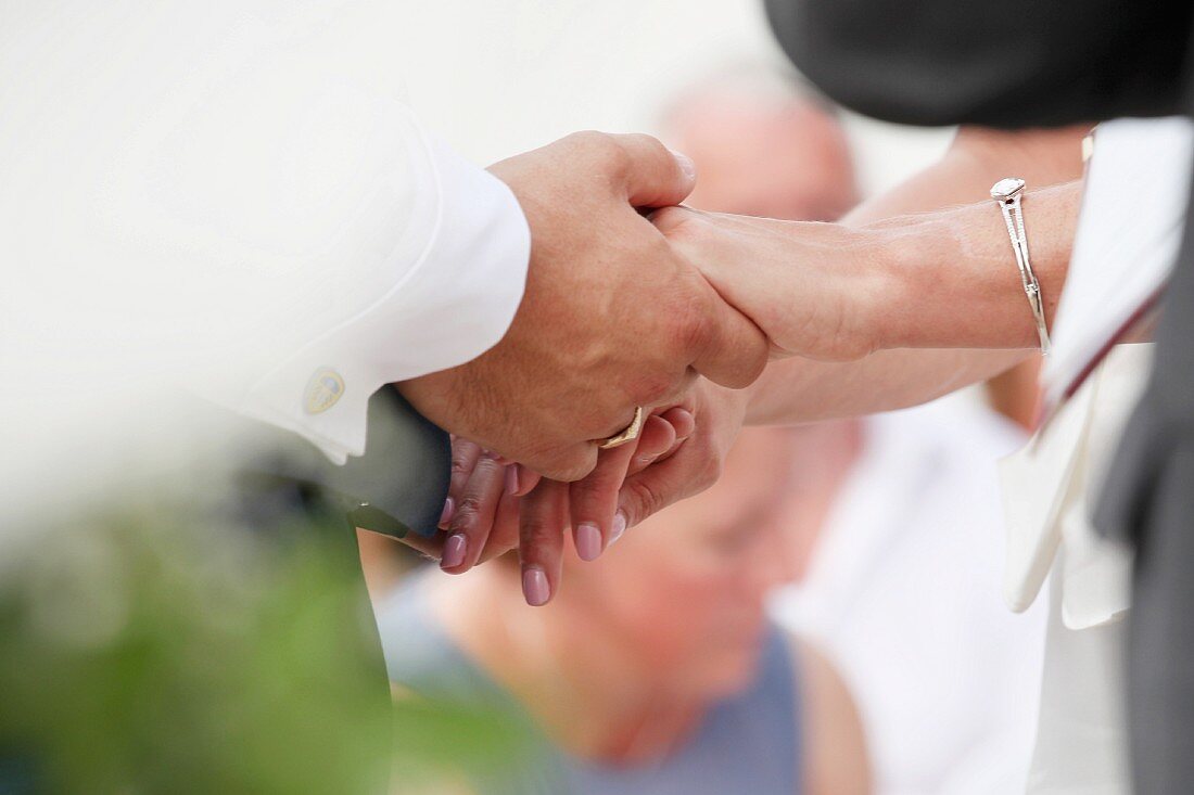 Hochzeitspaar hält sich an den Händen