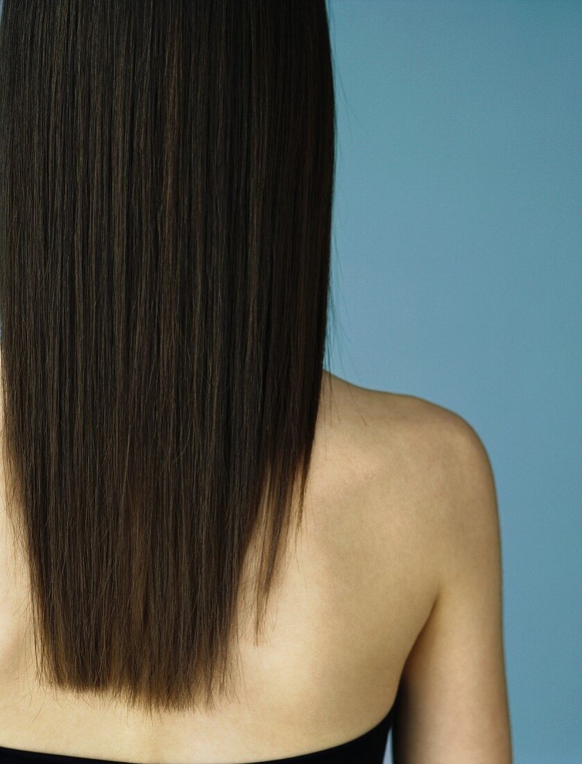 A brunette woman with long hair seen from behind